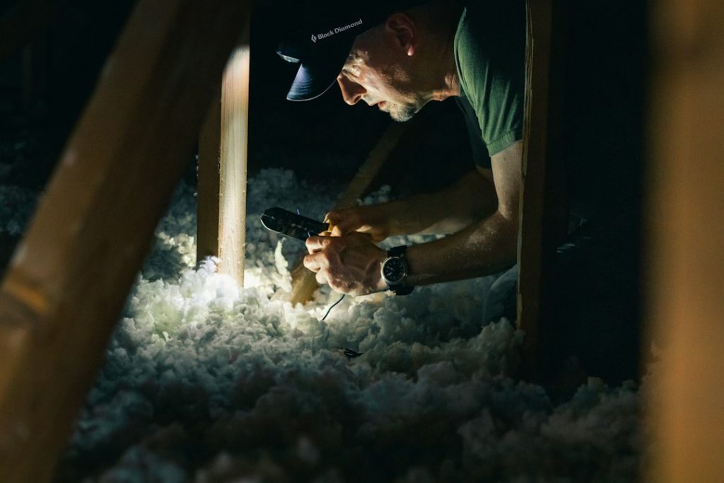 Person inspecting a dark attic