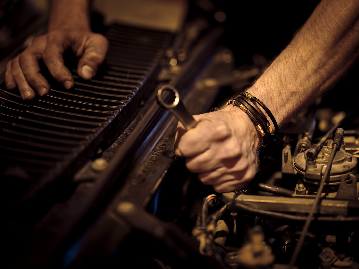 Mechanic working on a car engine with a wrench