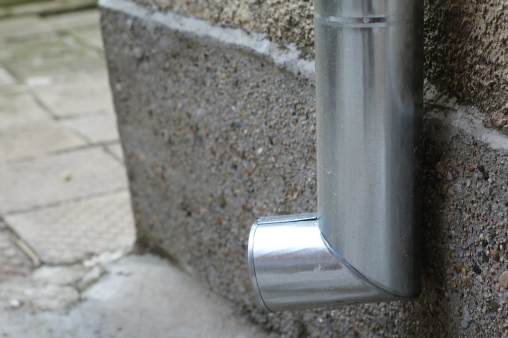 Rain gutter and downspout for gutter overflow guide