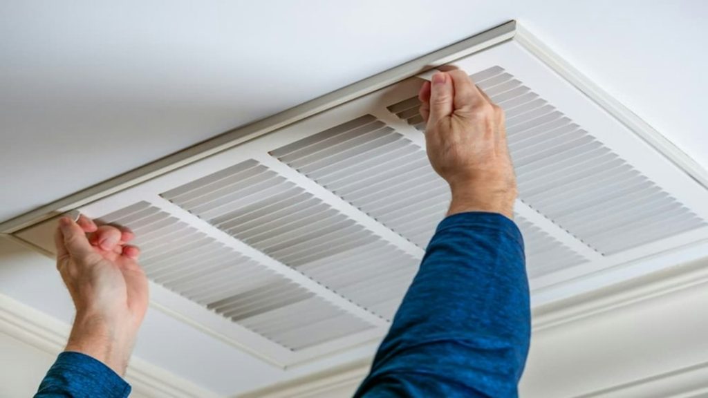 HVAC technician working near an indoor air system