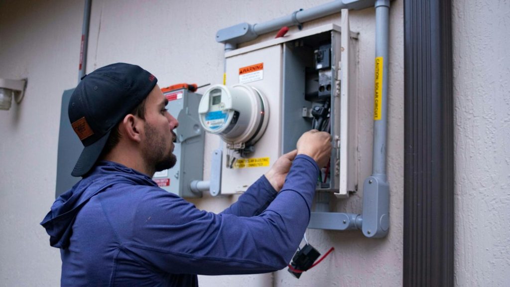 Home service technician working on an electrical system, illustrating covered home repairs